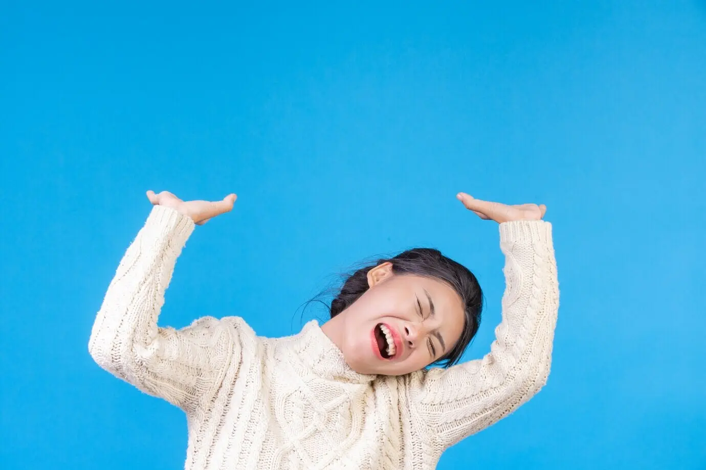 Красивая женщина, одетая в новый белый ковер с длинными рукавами, демонстрирует жест на синем. Трейдинг.