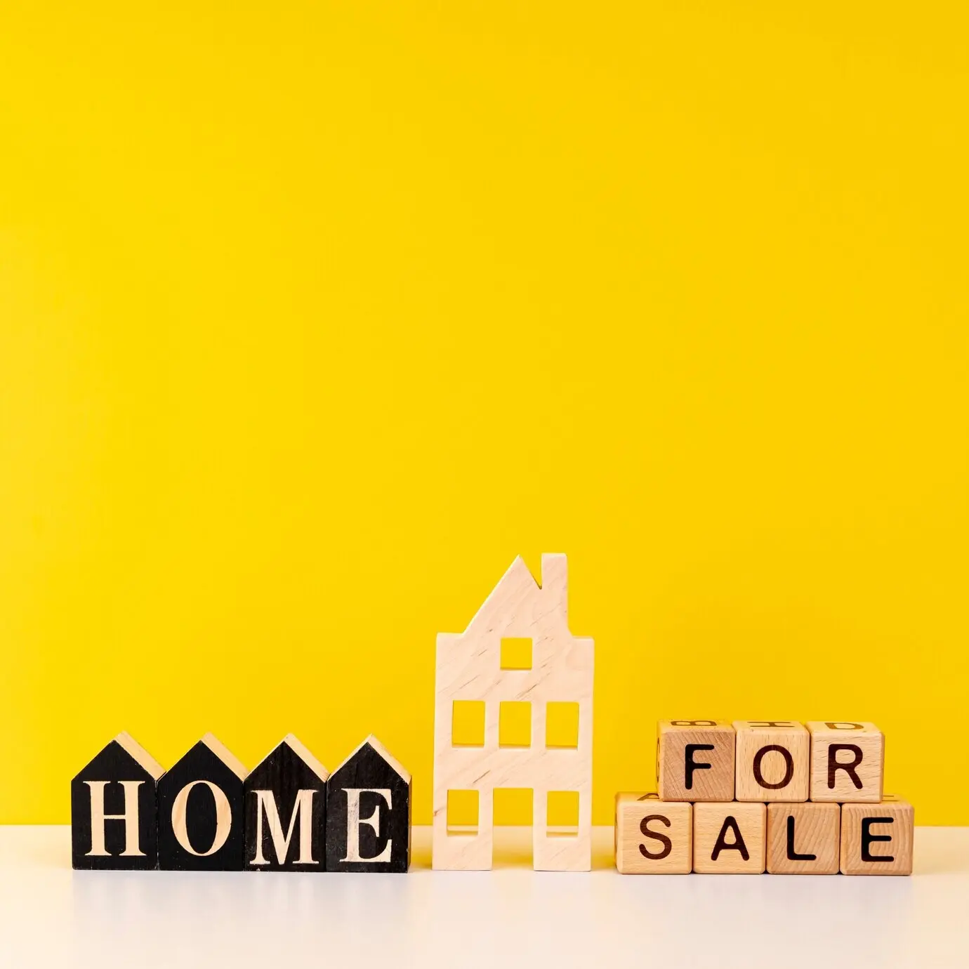 Надпись «Продаётся дом» на жёлтом фоне.